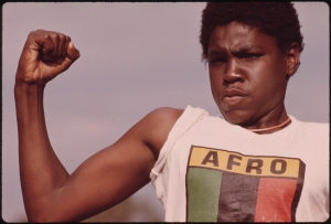A young, black man showing his muscle during a small community program in Chicago.